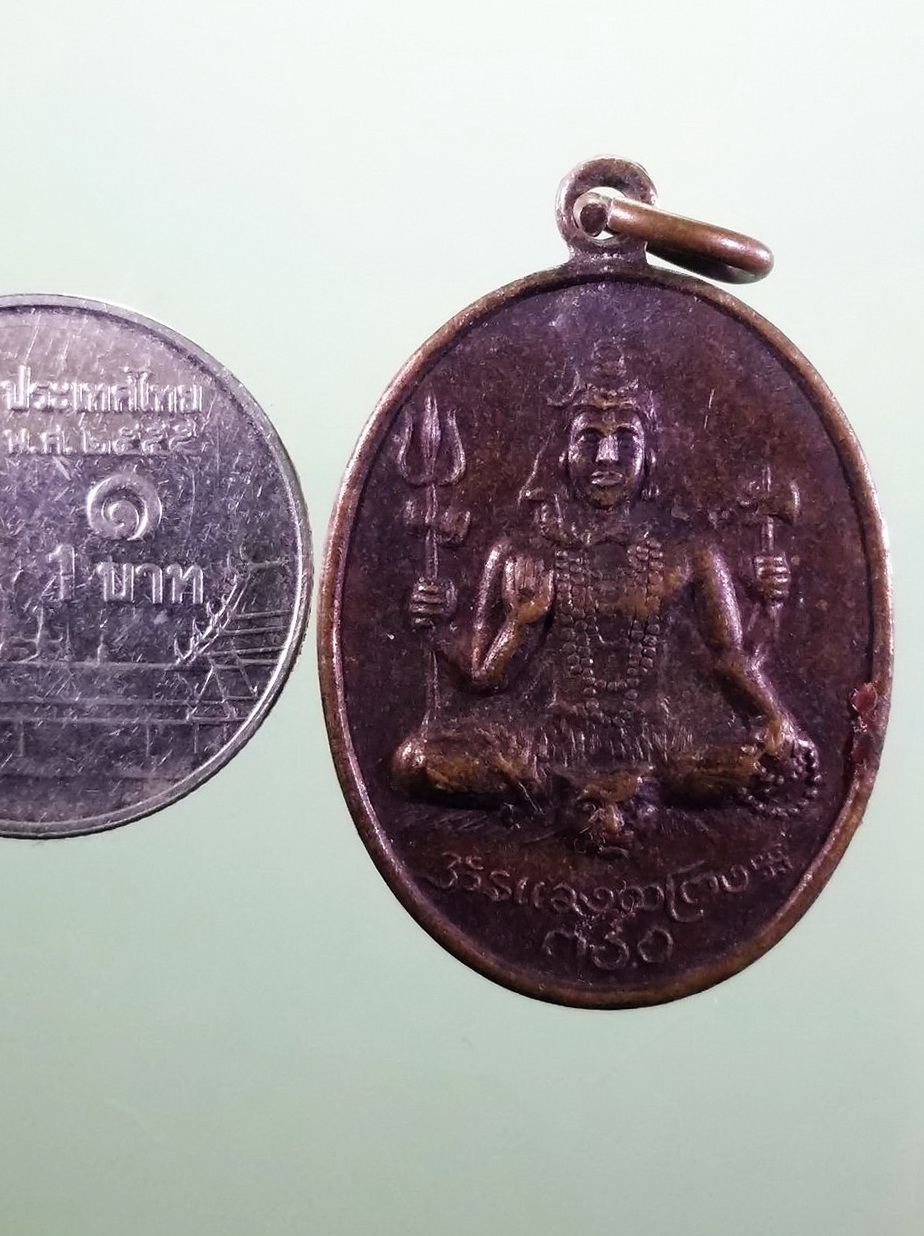 รหัสสินค้า เทพจีน - เทพฮินดู 129 เหรียญพระอิศวร หลังพระพิฆเณศวร เทพเจ้าแห่งความสำเร็จ วัดแขกสีลม กรุงเทพฯ สร้างปี 2514 สภาพผิวหิ้ง มีรอยยางวง ละลายติดอยู่ที่เหรียญ เอาไปทำความสะอาดเอาเองนะครับ