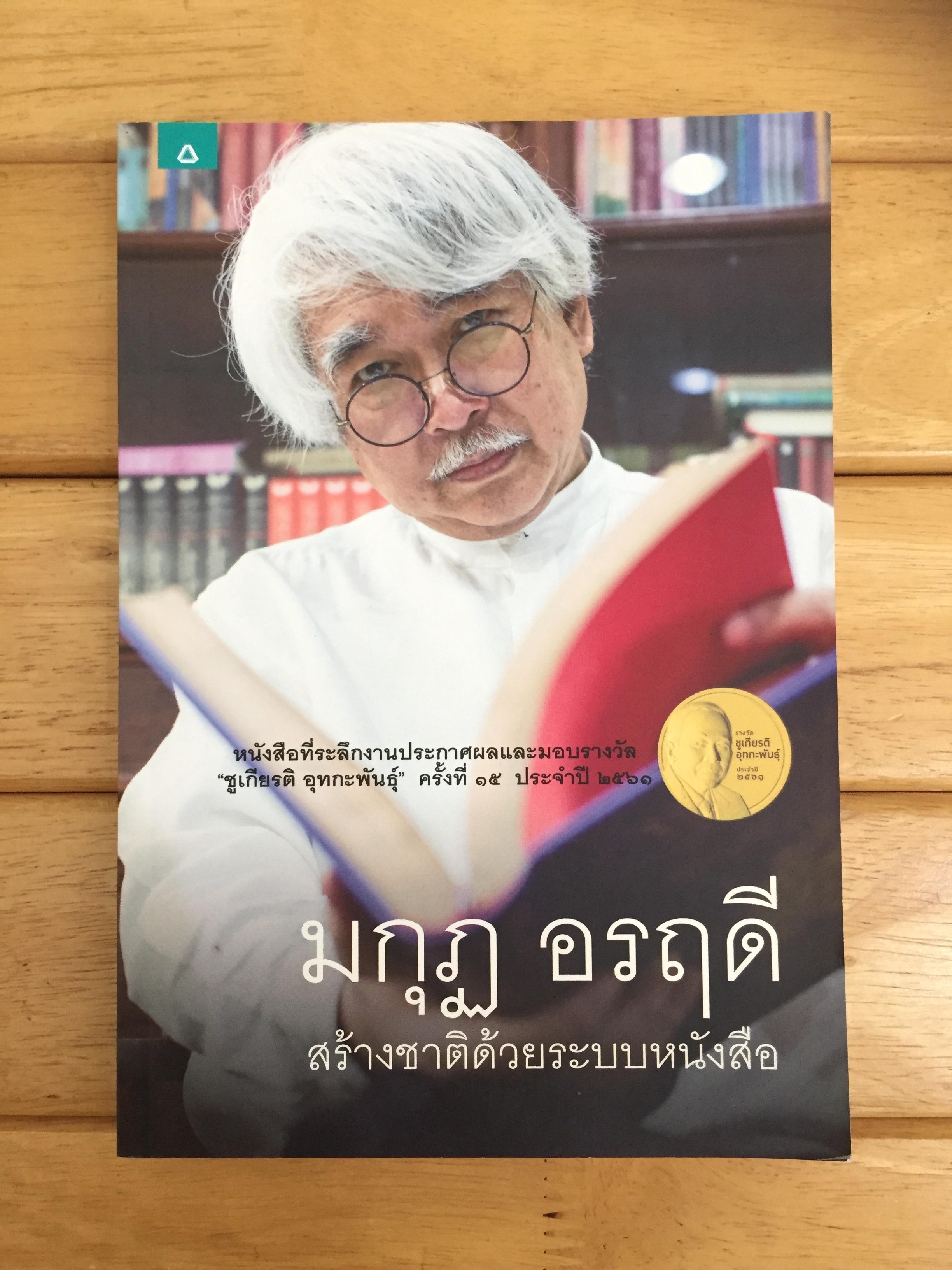 หนังสือที่ระลึกงานประกาศผลและมอบรางวัล ชูเกียรติ อุทกะพันธุ์ 'มกุฏ อรฤดี' สร้างชาติด้วยระบบหนังสือ