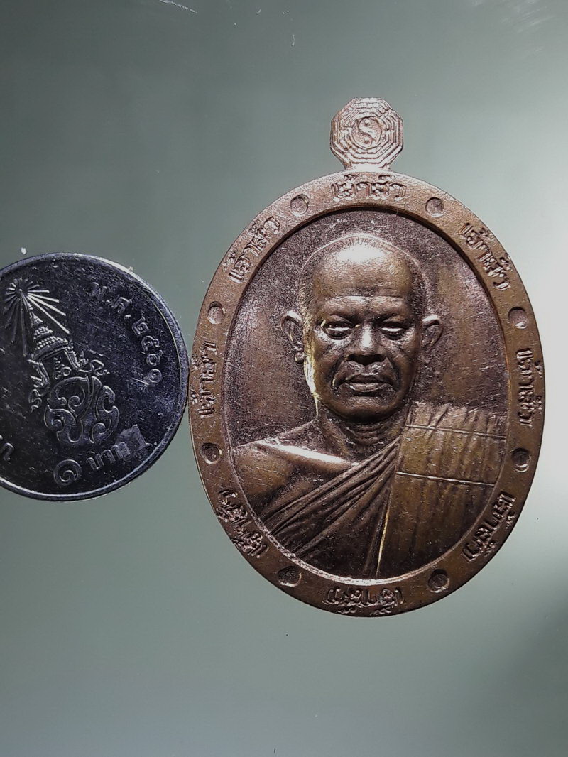Antig FB 12880 เหรียญรูปไข่ครึ่งองค์ หลวงพ่อสุริยันต์ โฆสปัญโญ วัดพุทธานาราม วัดป่าววังน้ำเย็น อำเภอเมือง จังหวัดมหาสารคาม ตอกโค๊ต หมายเลข 225 เนื้อทองแดงผิวไฟ