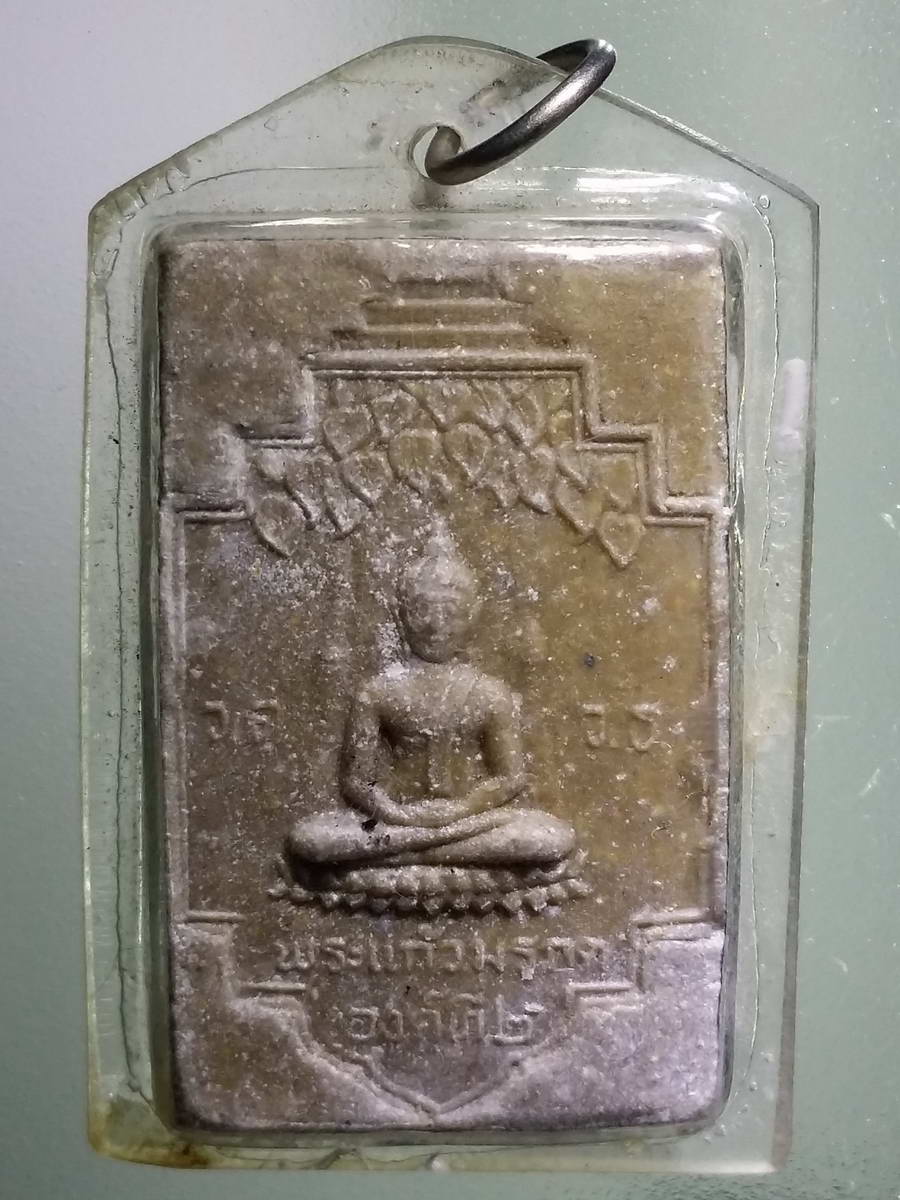 รหัสสินค้า พระเนื้อดิน เนื้อผง เนื้อว่าน 2584 พระแก้วมรกตเนื้อผง วัดเขาชายธง จังหวัดนครสวรรค์ สร้างปี 2520 พระอยู่ในเลี่ยมพลาสติกมาแต่เดิม สภาพแชมป์โลก