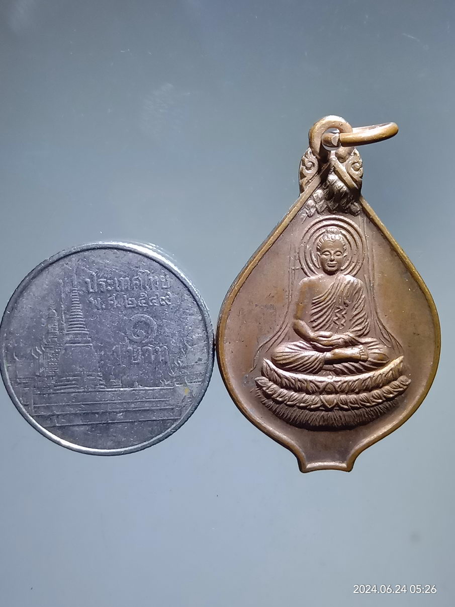 รหัสสินค้า เหรียญพระพุทธ 118 เหรียญพระพุทธเจ้ามหาศาสดาโลก รูปทรงของเหรียญ คล้ายดอกบัว ด้านหน้าเป็นรูปองค์สัมมาสัมพุทธเจ้าบรรลุสัมโพธิญาณ ด้านหลัง มีรวงข้าวล้อมรอบอักขระขอม ไม่ทราบที่