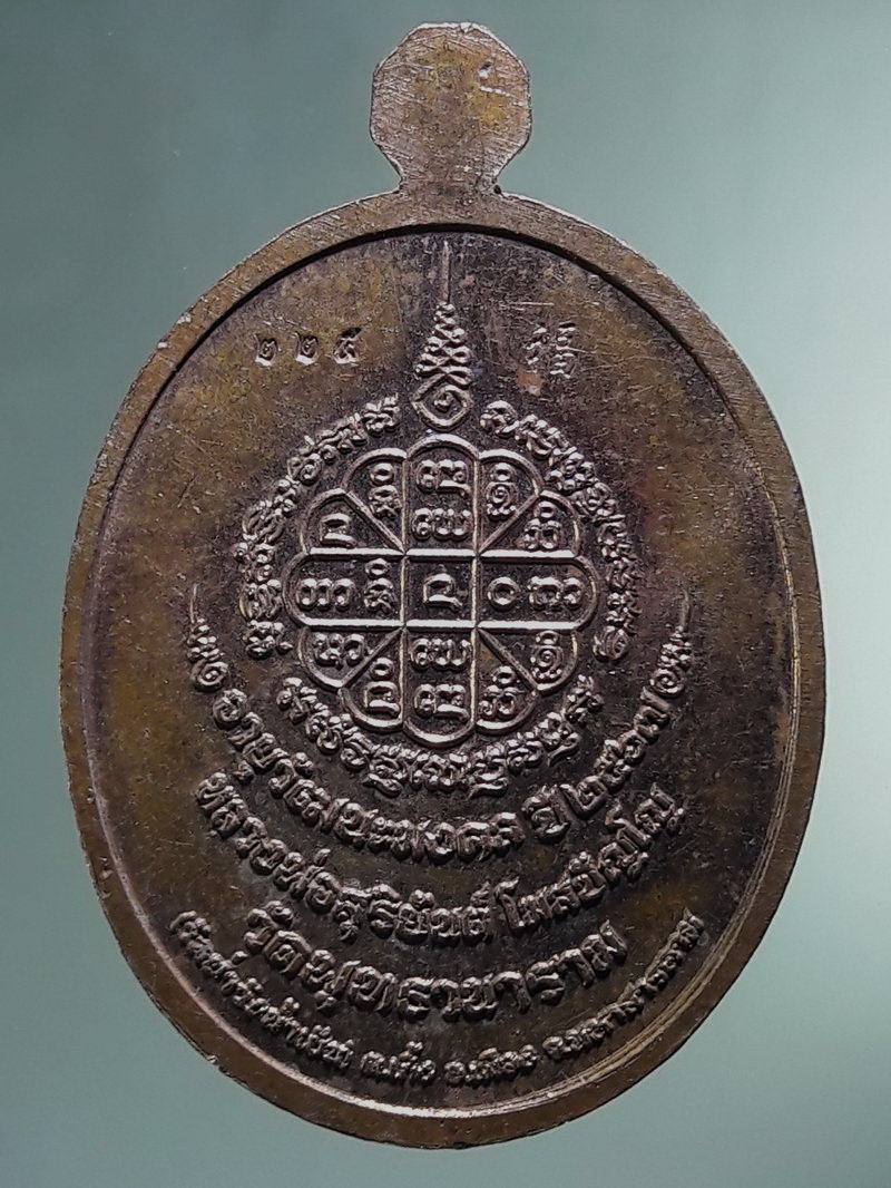 Antig FB 12880 เหรียญรูปไข่ครึ่งองค์ หลวงพ่อสุริยันต์ โฆสปัญโญ วัดพุทธานาราม วัดป่าววังน้ำเย็น อำเภอเมือง จังหวัดมหาสารคาม ตอกโค๊ต หมายเลข 225 เนื้อทองแดงผิวไฟ