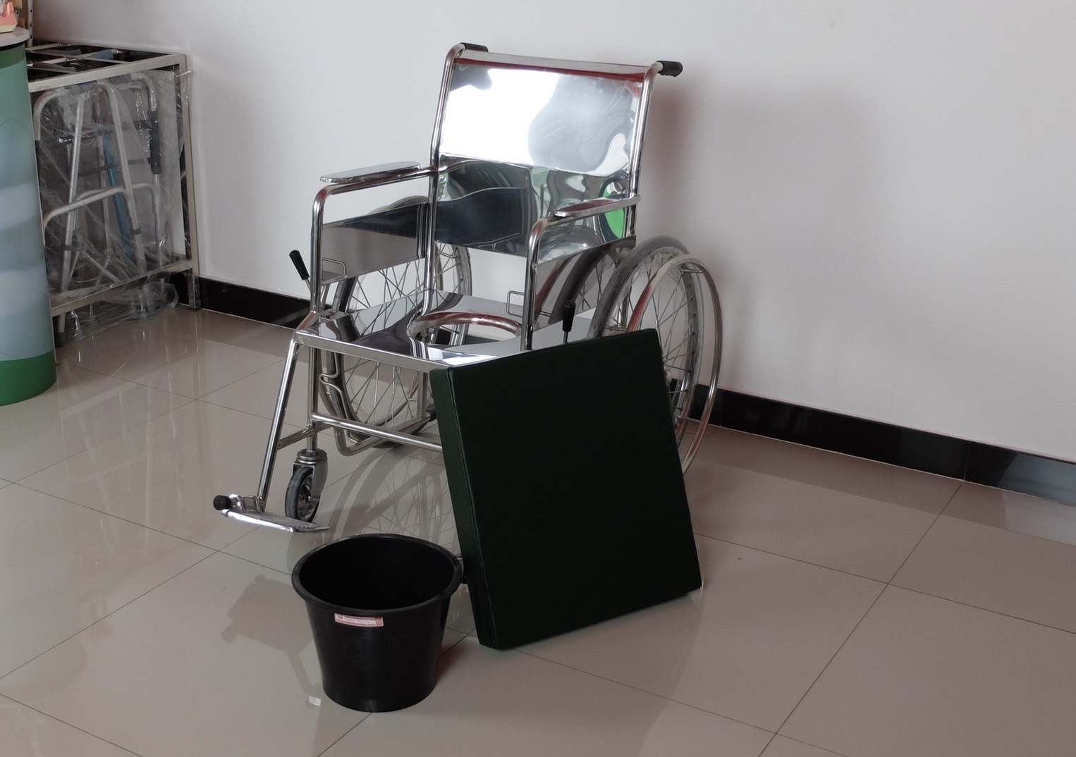 วีลแชร์นั่งถ่ายสแตนเลส รุ่น PS97 แบบพับไม่ได้ พร้อมเบาะรองนั่ง และถังรองถ่าย (ล้อหลังใหญ่)