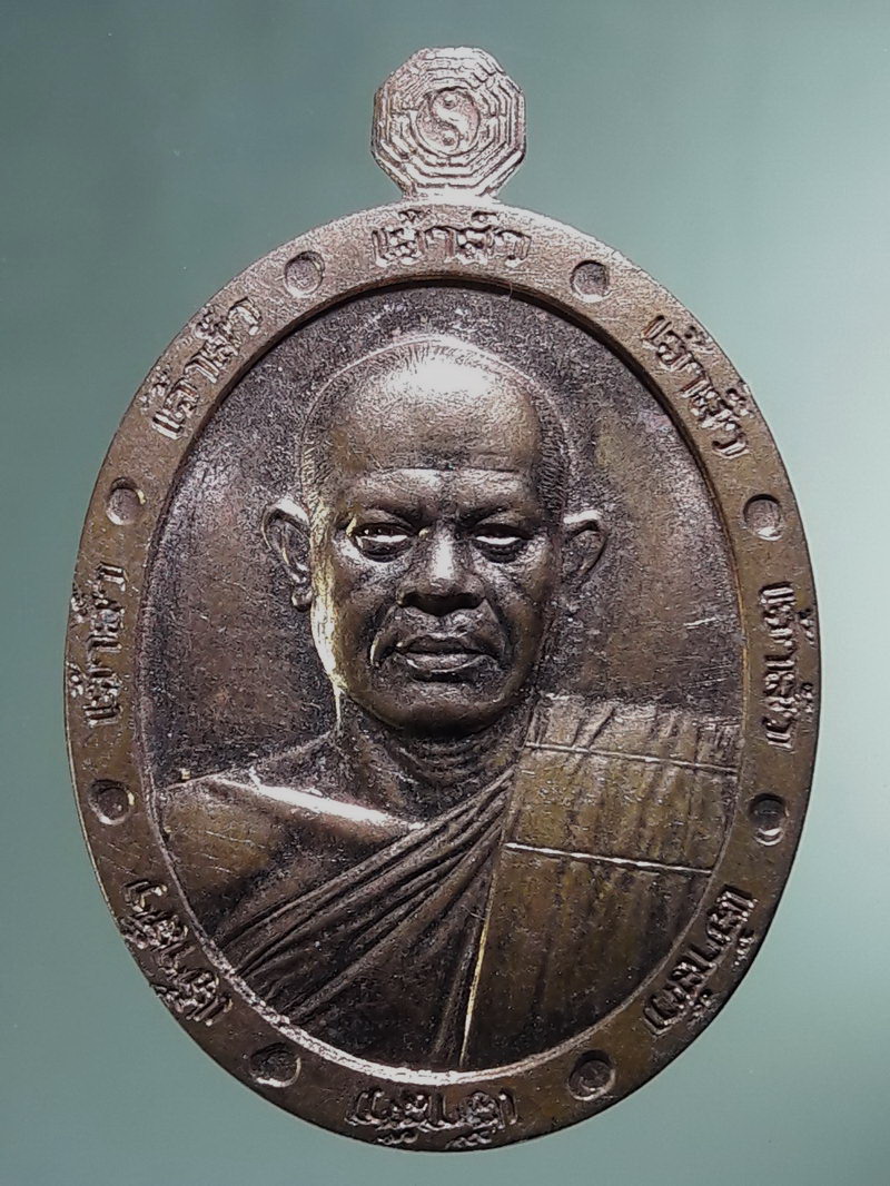 Antig FB 12880 เหรียญรูปไข่ครึ่งองค์ หลวงพ่อสุริยันต์ โฆสปัญโญ วัดพุทธานาราม วัดป่าววังน้ำเย็น อำเภอเมือง จังหวัดมหาสารคาม ตอกโค๊ต หมายเลข 225 เนื้อทองแดงผิวไฟ