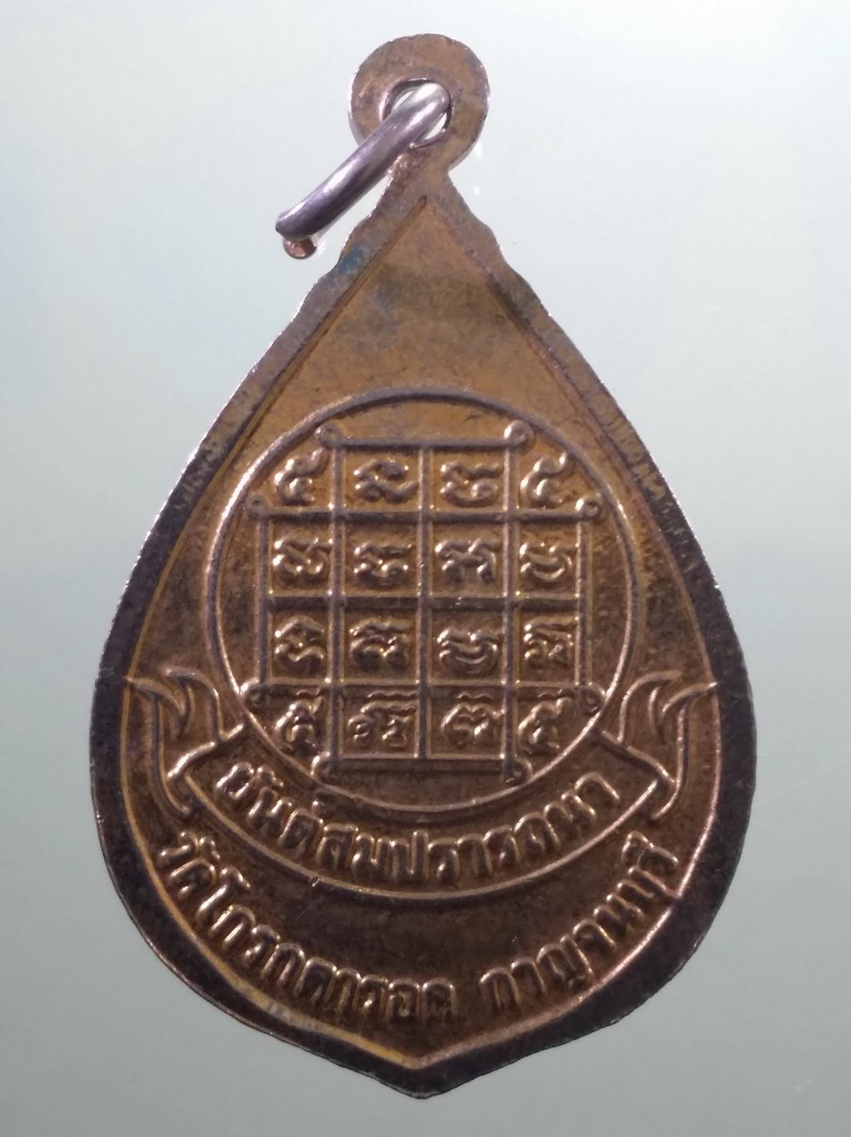 รหัสสินค้า เหรียญพระพุทธ 4120 เหรียญหยดน้ำกะไหล่ทอง พระพุทธเจ้า มหาศาสดาโลก นั่งบนบัลลังก์ดอกบัว เปล่งประกายรัศมี หลังยันต์สมปรารถนา วัดโกรกตารอด จังหวัดกาญจนบุรี