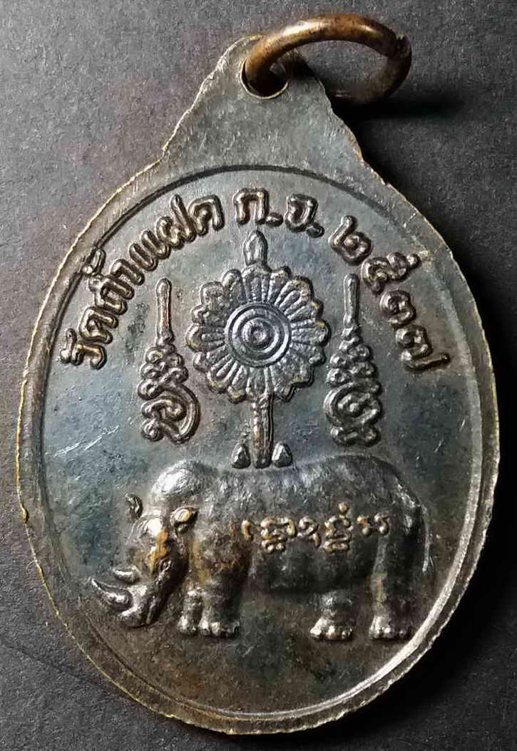 รหัสสินค้า กาญจนบุรี 011 เหรียญทองแดงรมดำ หลังแรด หลวงพ่อสัมฤทธิ์ วัดถ้ำแฝด จังหวัดกาญจนบุรี สร้างปี 2537 ตอกโค๊ต