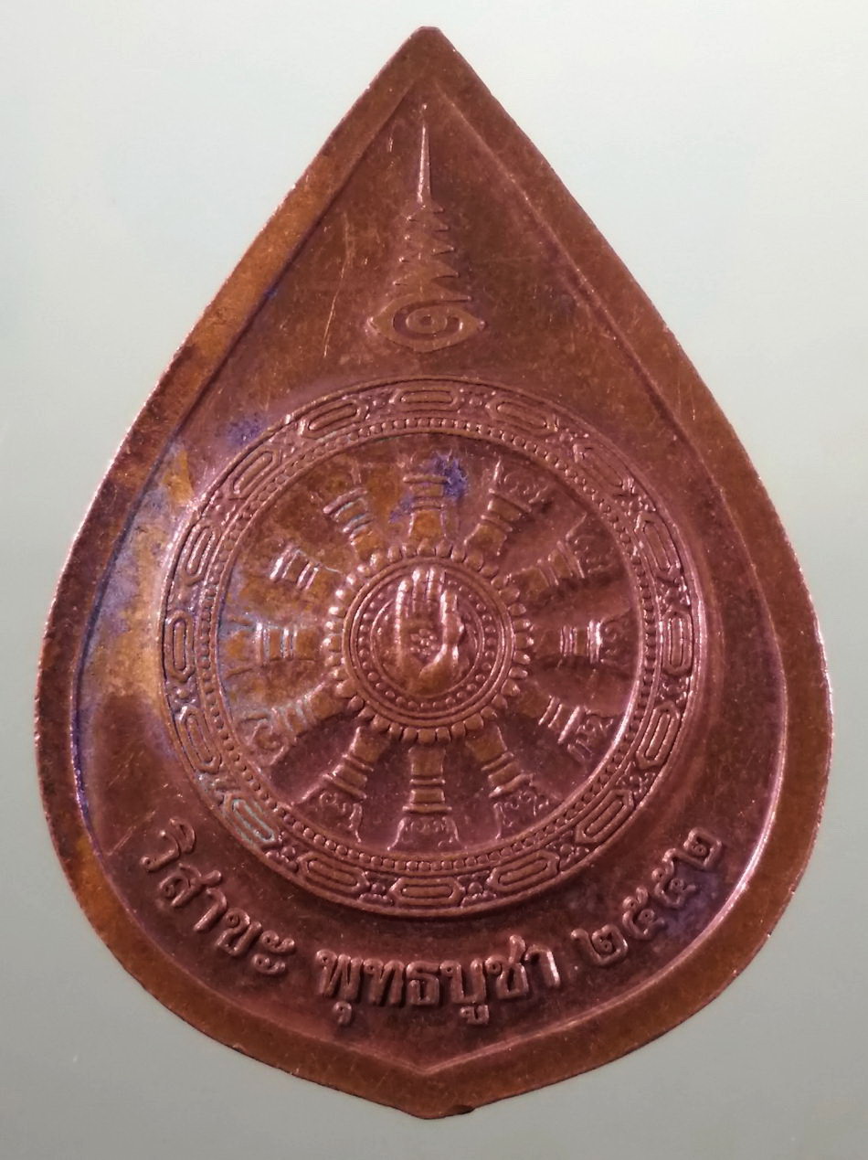 รหัสสินค้า เหรียญพระพุทธ 4231 เหรียญพระพุทธนิรโรคันตรายชัยวัฒน์จตุรทิศ หลังกงล้อธรรมจักร ที่ระลึกวิสาขพุทธบูชาปี 2552 เนื้อทองแดงผิวไฟ ขนาดเทียบกับเหรียญบาท