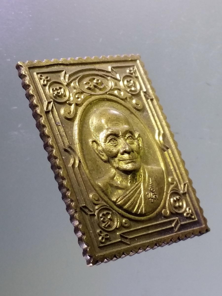 Antig Pim 102 เหรียญแสตมป์เนื้อทองฝาบาตร หลวงพ่อพูล วัดไผ่ล้อม จังหวัดนครปฐม หลังยันต์ดวงมงกุฎพระพุทธเจ้า และยันต์พระเจ้า 16 พระองค์