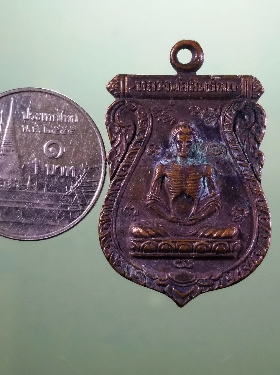 รหัสสินค้า เหรียญพระพุทธ 4226 เหรียญหลวงพ่อสิทธัตถะ พิมเสมาเนื้อทองแดง หลังหลวงพ่อศิริชัยวัฒน์ วัดมะเกลือ สร้างปี 2522 ขนาดเทียบกับเหรียญบาท พระสภาพผิวหิ้ง