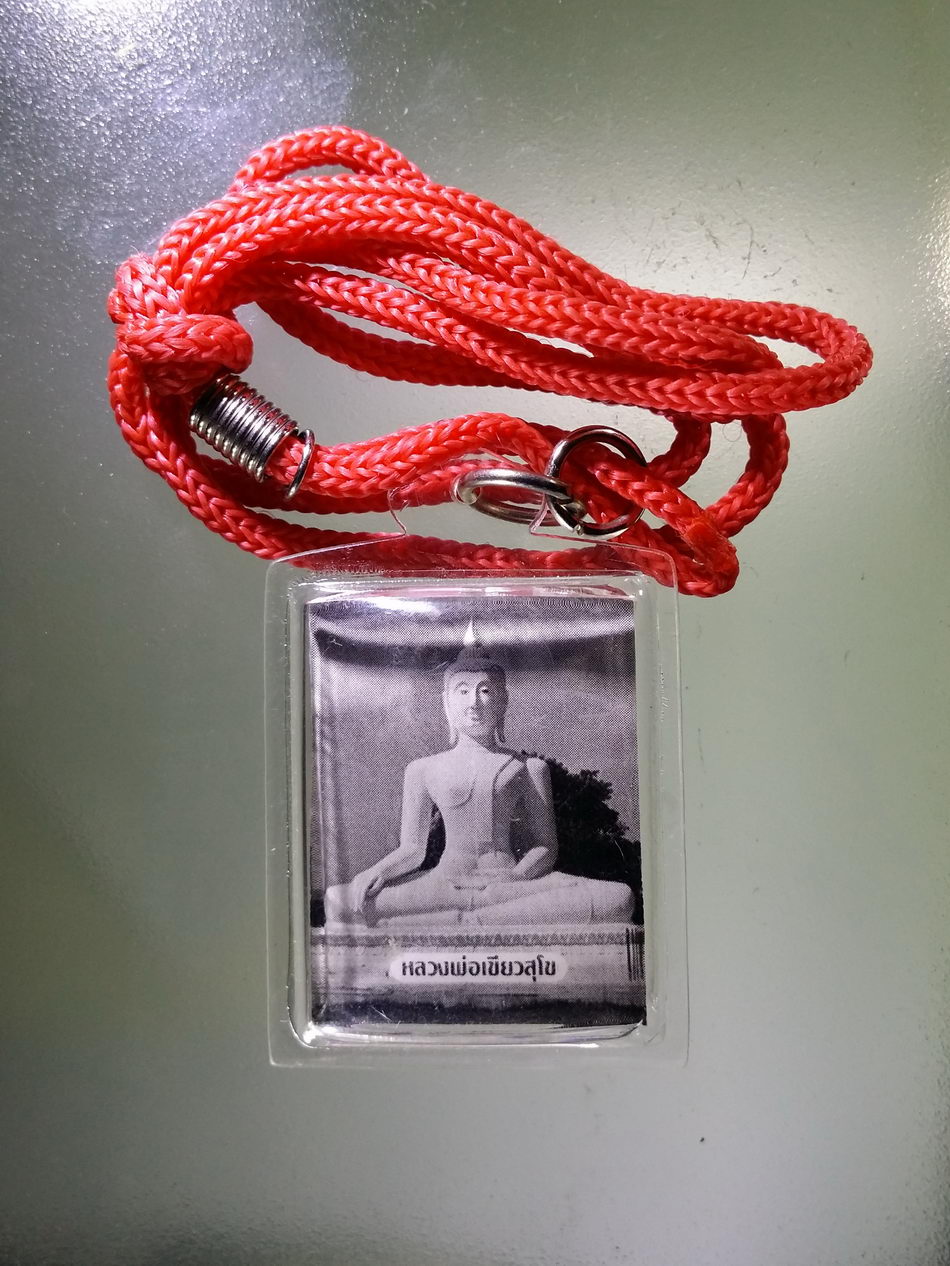 Antig Pim 344 ภาพถ่ายหลวงพ่อเขียวสุโข ด้านหลังปั๊มยันต์หมึกปี 2565 เลี่ยมพลาสติกเดิมจากวัด พร้อมสร้อยเชือกร่ม