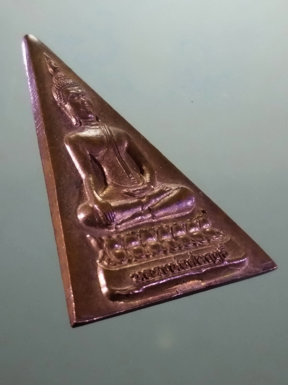 รหัสสินค้า เหรียญพระพุทธ 4228 เหรียญพระพุทธหลวงพ่อสัมฤทธิ์ รูปทรงสามเหลี่ยม ด้านหลังมีชื่อย่อวัด ว.ด.พ. สร้างปี 2560 ขนาดเทียบกับเหรียญบาท