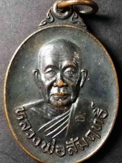 รหัสสินค้า กาญจนบุรี 011 เหรียญทองแดงรมดำ หลังแรด หลวงพ่อสัมฤทธิ์ วัดถ้ำแฝด จังหวัดกาญจนบุรี สร้างปี 2537 ตอกโค๊ต